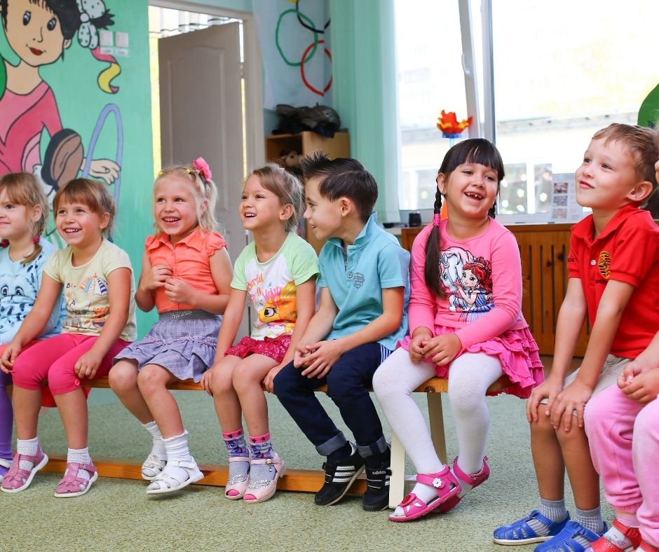 in den kindergarten stuhlkreixs fröhliche Kindergartenkinder im Stuhlkreis