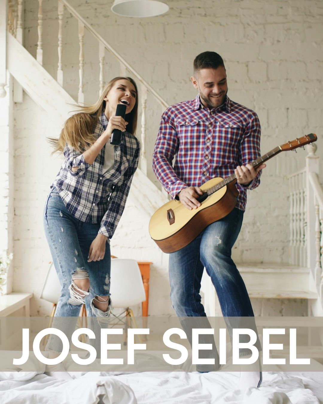 paar singt und spielt gitarre auf dem bett