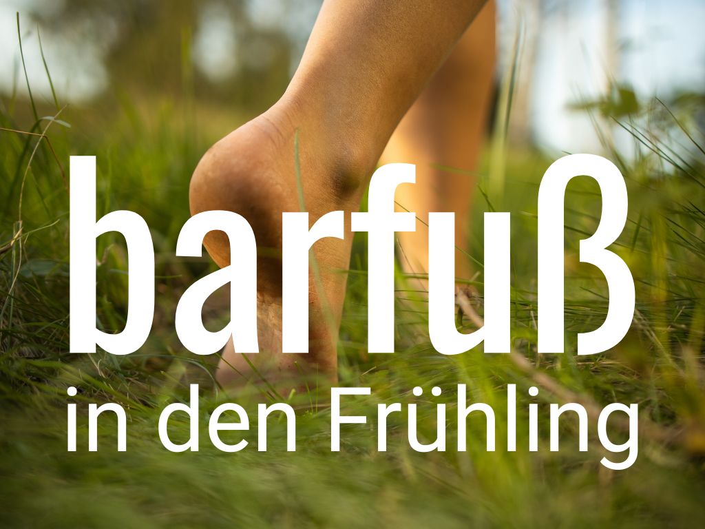 nackte Füße laufen über gras vorhinter der Schrift barfuß in den Frühling