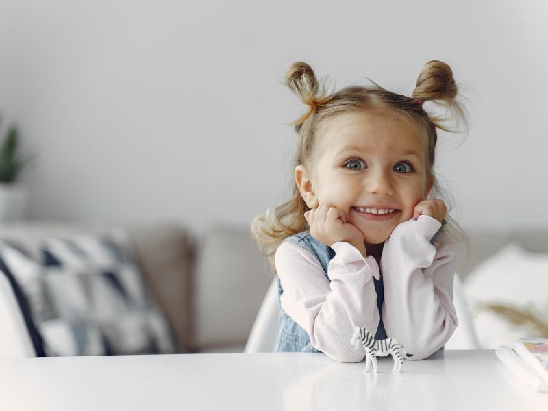 kleines Mädchen für Richter Kinderschuhe Süßes Mädchen mit Zöpfen und Spielfigur Zebra