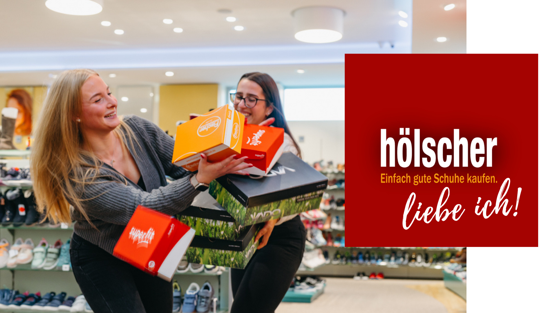 zwei frauen versuchen erfolglos schuhkartons zu tragen