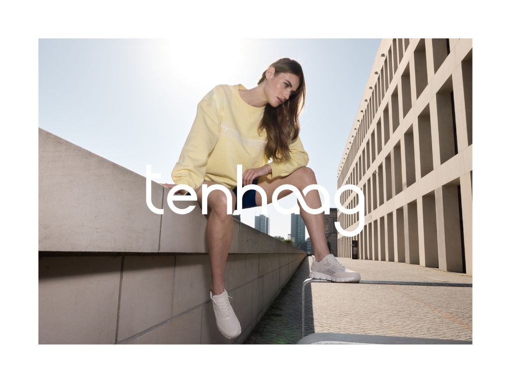 Frau sitz auf Betongallerie mit tenhaag schuhen