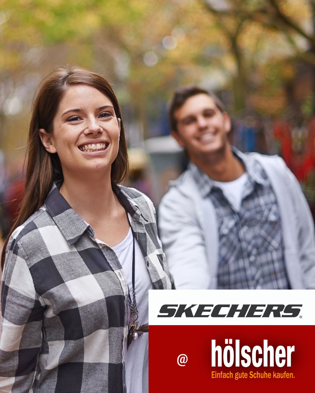 Pärchen läuft lächelnd auf kamera zu  mit skechers at schuh hoelscherlogos